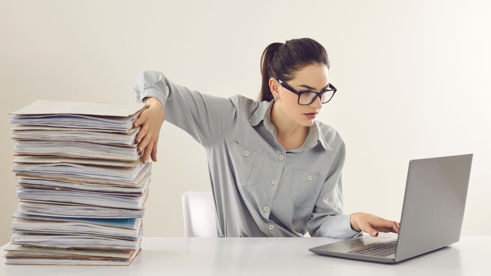 Office worker pushing away a big pile of documents